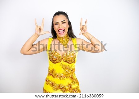 Young beautiful woman wearing carnival costume over isolated white background shouting with crazy expression doing rock symbol with hands up