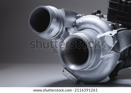 New car turbine on a gray background. Blower for air intake system