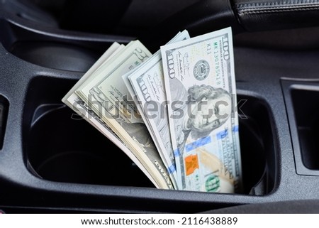 A wad of dollars inside the car. A wad of dollars inside the car. Royalty-Free Stock Photo #2116438889