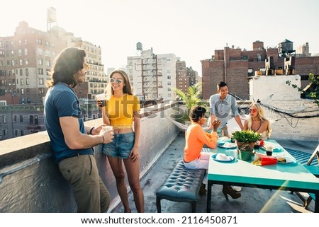 Storytelling image of a group of teenagers making party on a rooftop in New york city. Concept about lifestyle and youth