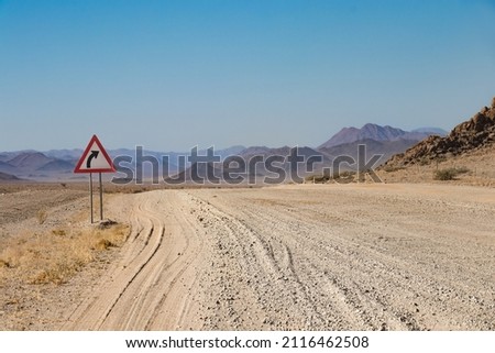 close up of a washboard gravel road and warning road sign in Namibia