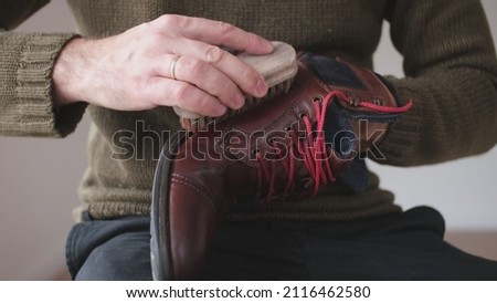 Caucasian Male Polishing Brown Leather Boots Shoes with Soft Brush After Waxing Waterproffing and Impregnating with Shoe Shine Wax Royalty-Free Stock Photo #2116462580