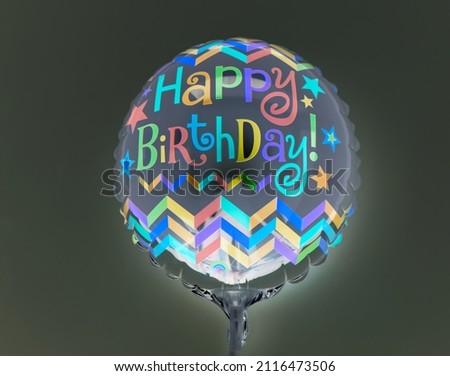 Happy birthday message on a neon balloon. Glow in the dark balloon. 