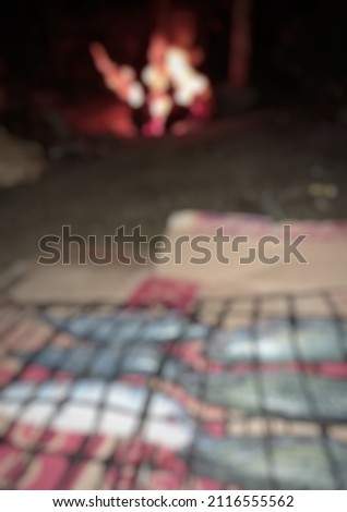 defocused abstract background of grilled fish, at night
