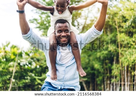 Portrait of enjoy happy love black family african american father carrying daughter little african girl child smiling and having fun moments good time in summer park at home