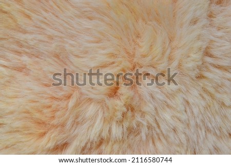 Close-up of light orange fur fabric background