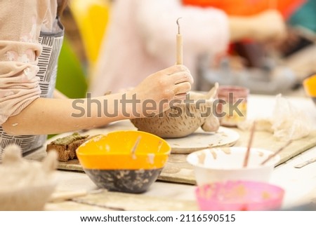 Cute little kid playing with modeling clay in pottery workshop, craft and clay art, child creative activities, education in Arts Royalty-Free Stock Photo #2116590515