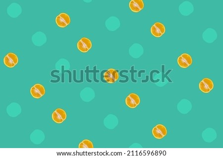 Colorful fruit pattern of fresh orange slices on green background with shadows. Top view. Flat lay. Pop art design
