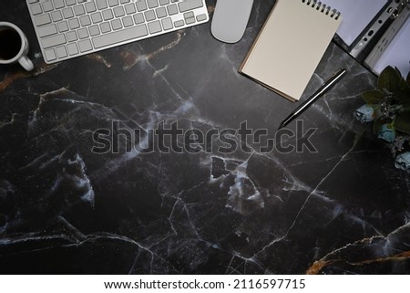 Top view empty notepad, wireless keyboard and mouse on marble background.