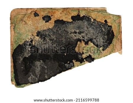 A piece of old yellowed faded green irregularly shaped cardboard with a torn edge, with stains and traces of glued black paper from an old photo album isolated on a white background