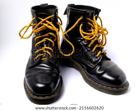 black boots with yellow laces. black leather boots isolated on white