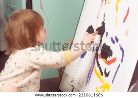 Caucasian toddler boy painting at home real life candid pictures