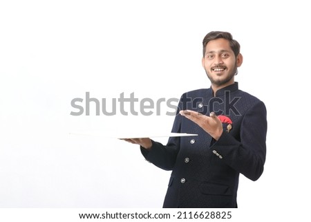 young indian man in traditional wear and giving expression on white background.