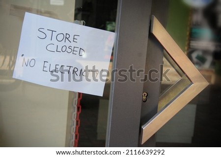 Sign posted in a shop window: Shop closed, no electricity. Energy crisis, blackouts concept.