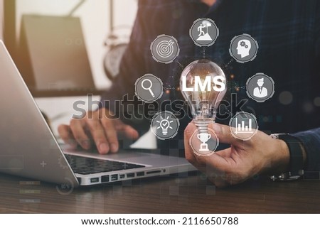 Horizontal banner close up successful businessman holding light bulb, LMS - Learning Management System web icon for lesson and online education, course, application, study, e learning. Royalty-Free Stock Photo #2116650788