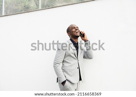 Portrait handsome African American business man talking with phone by white wall