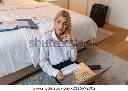 Business Woman working from a hotel room. Beautiful young woman thinking about new business ideas. Sitting on the ground working late at night