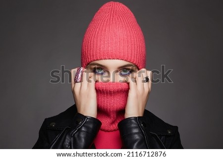 beautiful girl in balaclava and leather coat. Trendy Mask on pretty woman. New Hat style Royalty-Free Stock Photo #2116712876