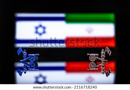 Conceptual image of war between Israel and Iran using toy soldiers and national flags on a reflective background