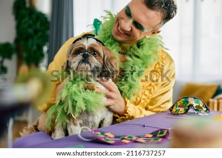 Cute dog and his owner wearing carnival costumes during Mardi Gras celebration.