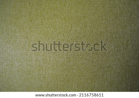 Closeup green fabric texture with copy space. Selective focus upholstery for furniture. Wallpaper and background. Thick gray material for the interior.