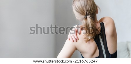 Woman with neck and back pain. Woman rubbing his painful back close up. Pain relief concept. Royalty-Free Stock Photo #2116765247