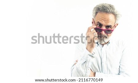 Gray haired man in pink sunglasses posing to the camera - happiness in elderly age concept - isolated copy space. High quality photo
