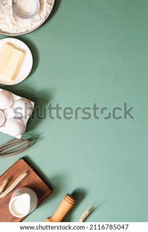 Frame of food ingredients for baking on a green pastel background. Cooking flat lay with copy space. Top view. Baking concept. Mockup. Royalty-Free Stock Photo #2116785047