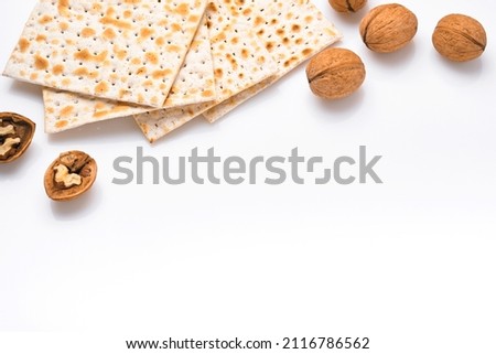 Matzah and walnut. Traditional ritual Jewish bread on isolated on white background. Passover food. Pesach Jewish holiday of Passover celebration concept. Traditional Jewish kosher matzo. Mock up. Royalty-Free Stock Photo #2116786562