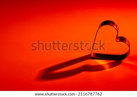 Red, orange yellow, gradient background. Metal heart. Lights and shadows. Love, wedding, Valentine 's day, engagement, romance, infatuation, marriage, fidelity, devotion, happiness, hot love, warmth. Royalty-Free Stock Photo #2116787762