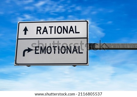 Road sign with words rational and emotional. White two street signs with arrow on metal pole on blue sky background. Royalty-Free Stock Photo #2116805537