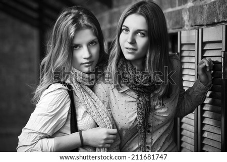 Two young fashion girls at the brick wall