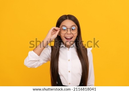 amazed teen girl in school uniform and glasses for vision protection, eyewear Royalty-Free Stock Photo #2116818041