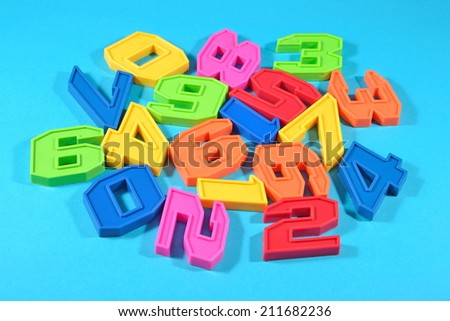 Plastic colored numbers on a blue background close up