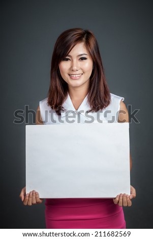 Asian girl hold blank sign and smile on gray background
