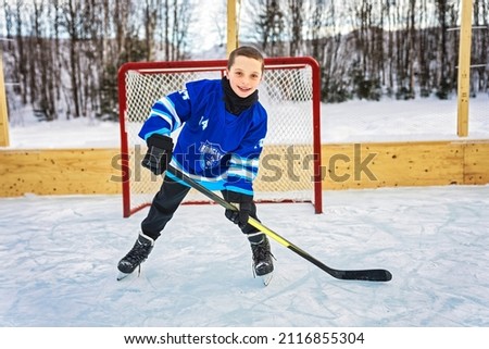 A Boy hockey play on winter season outside