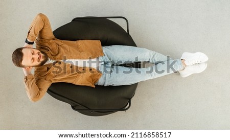 Happy Bearded Guy Relaxing With Eyes Closed Sitting In Chair At Home. Lazy Contented Male Resting And Sleeping Holding Hands Above Head Enjoying Domestic Weekend. Top View, Panorama