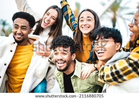 Multicultural students cheering at travel location - Life style concept with guys and girls having fun together out side - College mates posing for selfie picture on school vacations - Warm filter