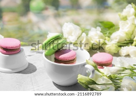 Eustoma and macaroon on a light background. Delicate composition, postcard, congratulations, good morning. Delicious dessert.