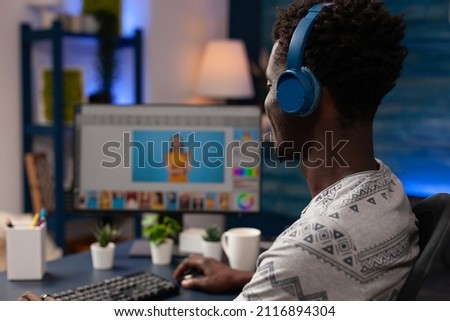 African american editor editing picture using retouching software working at photo contrast sitting at desk in creativity studio. Professional illustrator making digital correction. Remote work