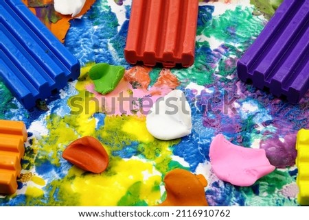 Multi colored rectangle pieces of plasticine lie on a cardboard with plasticine abstract painting, abstract background
