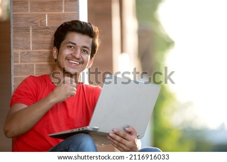 Indian college student with laptop in college campus, Confident student