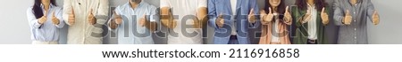 Happy business team doing thumbs up all together. Banner background with midsection shot of group of successful young and mature people in office suits standing in row, giving thumbs up and smiling Royalty-Free Stock Photo #2116916858