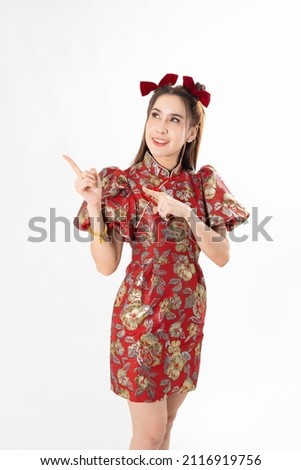 Happy Asian woman wearing traditional cheongsam qipao dress and hand gesture up pointing up to copy space isolated on White background. Happy Chinese new year Women with Happy Expression Concept