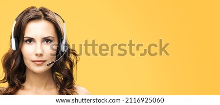 Call center help line service concept - closeup face portrait image of customer support phone sales operator in headset, over yellow color background. Brunette beautiful woman. Caller worker.