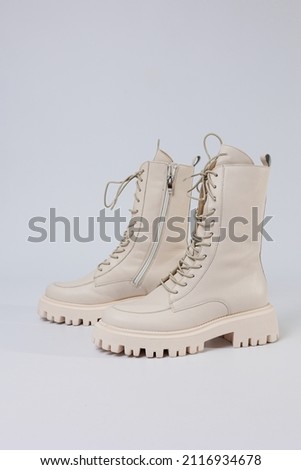 Women's white winter boots with fur with thick soles and laces. Advertising of the new collection of women's shoes 2022
