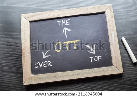 Over the top (OTT) media service concept on black chalkboard.