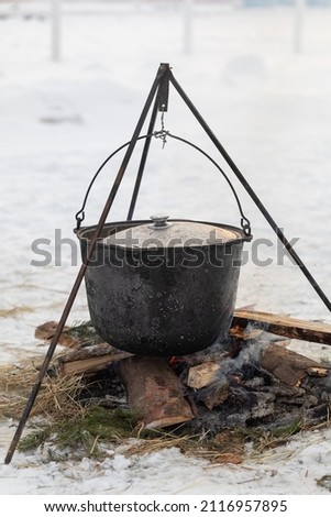 Cooking in camping conditions in a boiler on a fire outside in winter. campfire. nobody