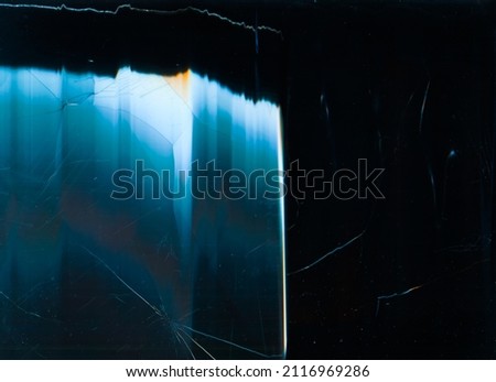 Broken overlay. Crushed texture. Damaged matrix. Blue orange digital distortion dust scratches on dark fractured glass abstract background.