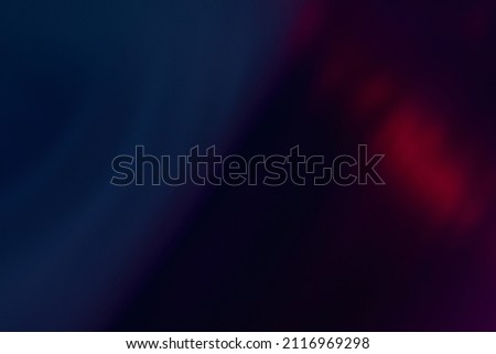 Lens flare overlay. Blur neon rays. Bokeh light leak texture. Defocused blue purple red color glow flecks on dark abstract empty space background.